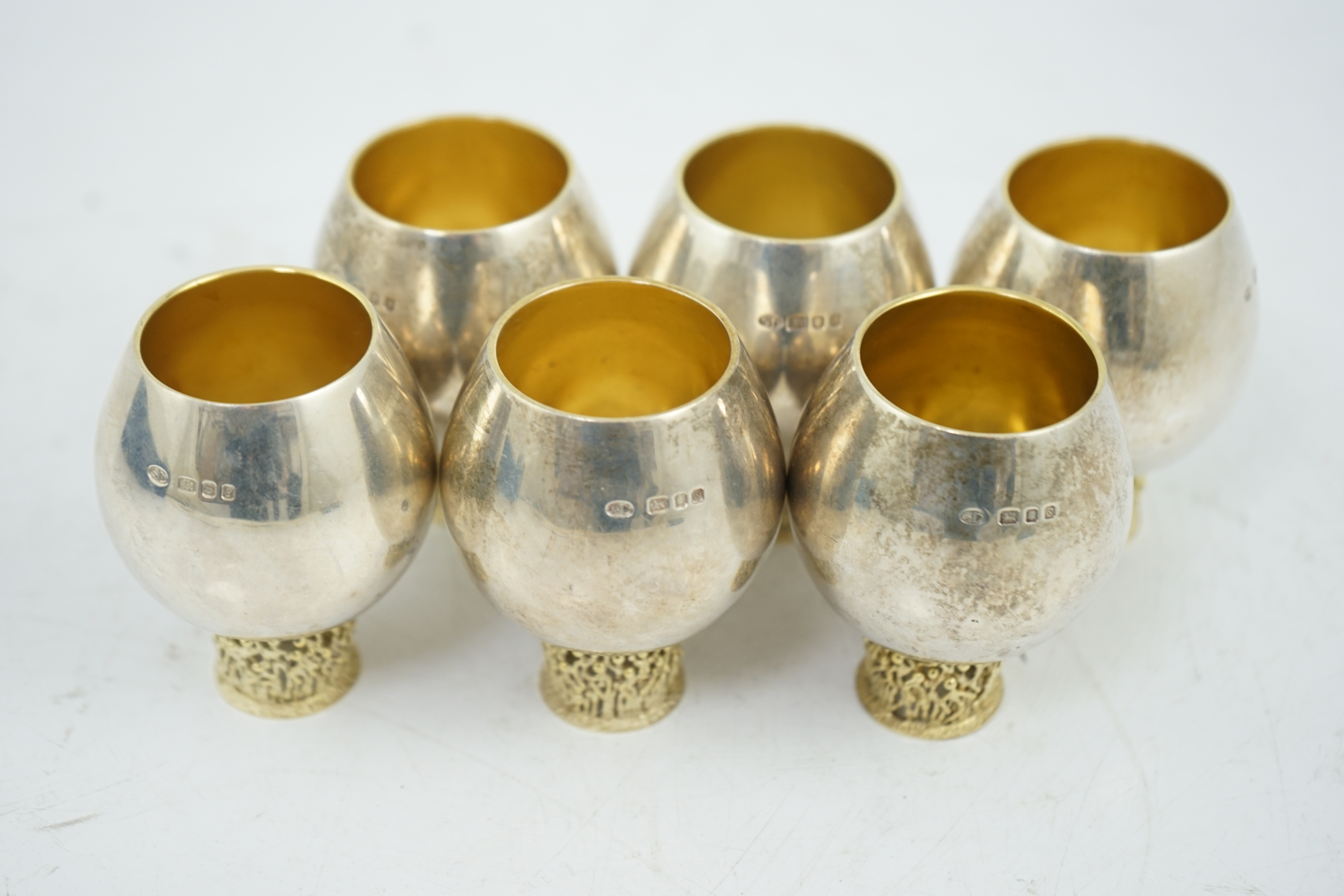 A set of six Elizabeth II Stuart Devlin parcel gilt silver balloon shaped pedestal tots